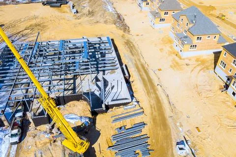 Construction site building frame machinery with houses around structure bei.. Stock Photos
