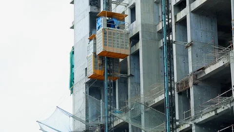 Construction site building with scaffolding elevator moving down Stock Footage 110245765