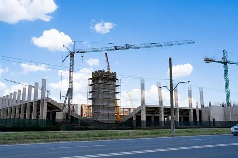Construction site, building under construction in the city, cranes and clou.. Stock Photos