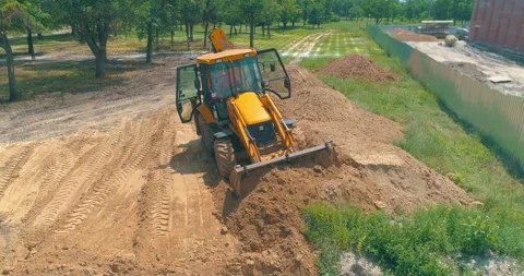 Construction site with computer graphics. The tractor works as a bucket on the Видео 168689248