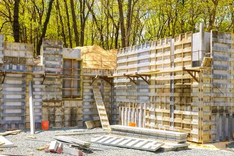 Construction site concrete forms being set up near wooded area Fotos de archivo