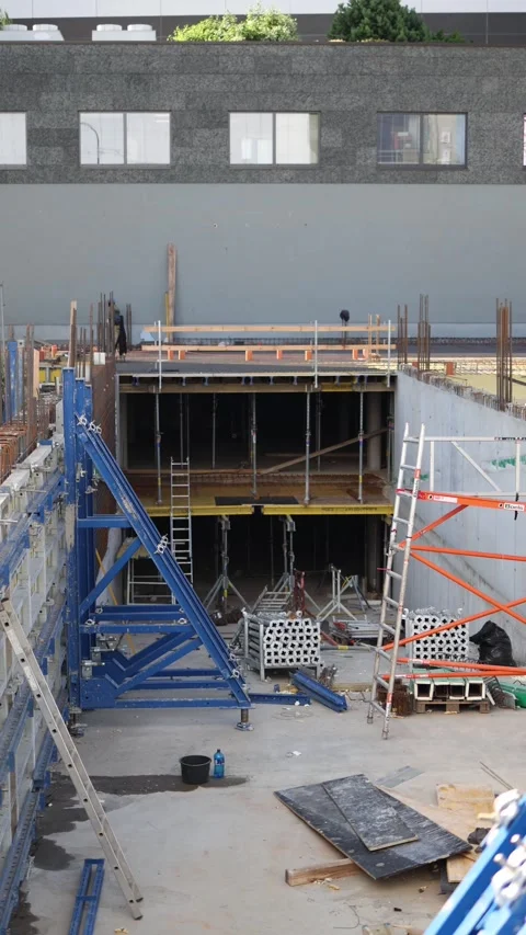 Construction site with concrete foundation and scaffolding as workers prepare fr Stock Footage 315159444