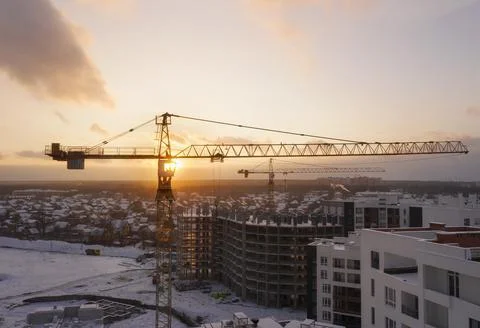 Construction site with construction cranes at sunset Stock Photos