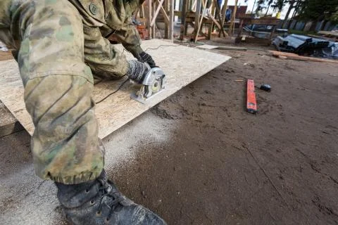 Construction Site. Construction worker with electrical circular saw saws the Stock Photos