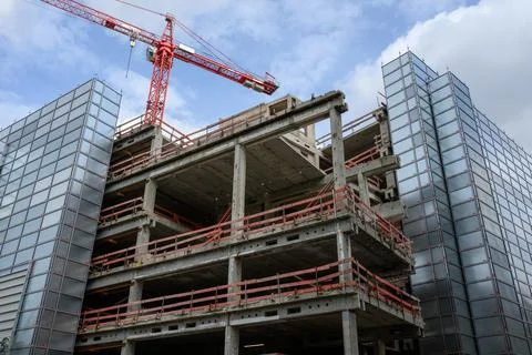 A construction site with a crane and the shell of a house Stock Photos