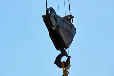 Construction site with crane lifting a heavy load under a clear sky Stock Photos