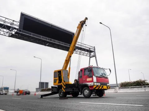 Construction site crane is lifting a led signboard for advertisement Stock Photos