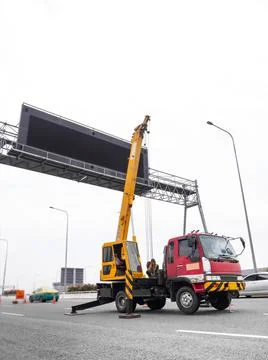 Construction site crane is lifting a led signboard for advertisement Foto stock