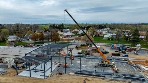 Construction Site With Crane Lifting Materials in Residential Area With Hou.. Stock Photos
