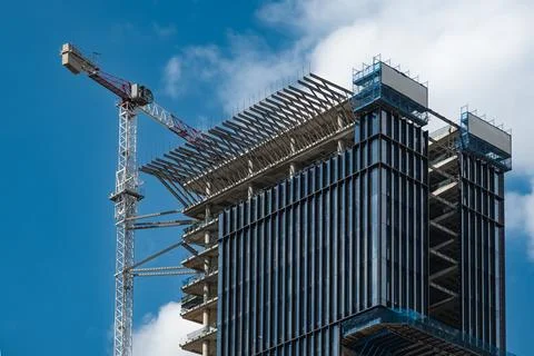 Construction site with crane working on a building complex, with blue sky b.. Stock Photos
