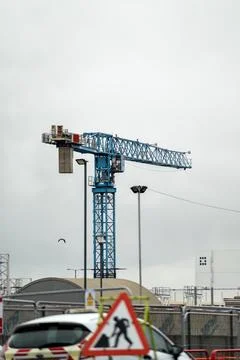 Construction site cranes against cloudy sky. Stock Photos