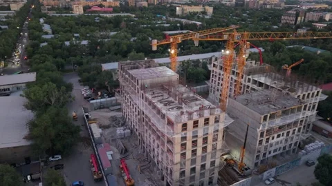 Construction site with cranes and city skyline at dusk, urban development scene Stock Footage 339124131