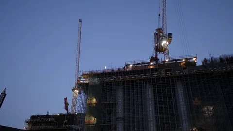 Construction site with cranes. Builder welds metal armature making sparkles 库存影片 121724072