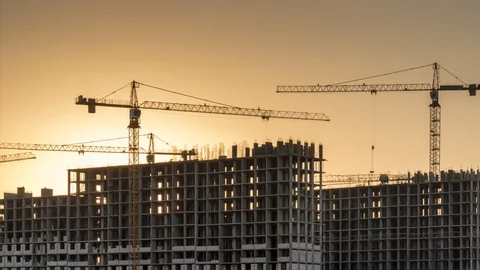 Construction site with cranes at orane yellow sunset. Video stock 129078178