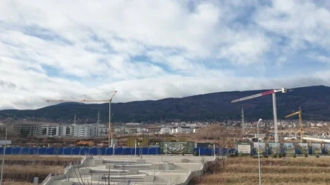 Construction site with cranes in time lapse with stormy clouds Stock Footage 148253554