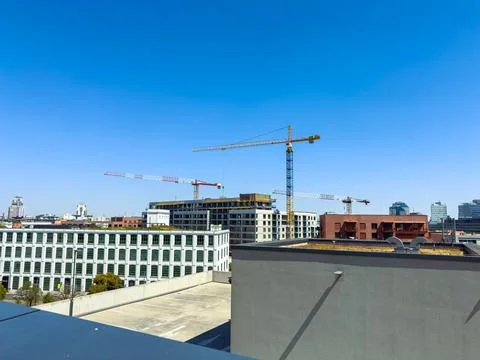 Construction site with cranes in an urban setting during daytime in the city Stock Photos