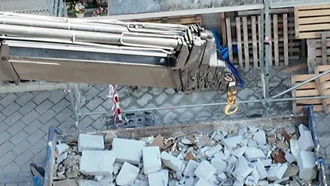Construction site demolition and debris removal with crane hook. Aerial view Stock Footage 336757961