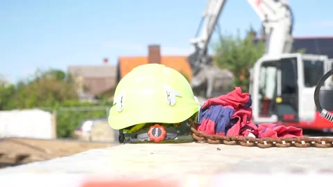 Construction site, demolition - Close up Helmet with excavator in the background 動画素材 130994348