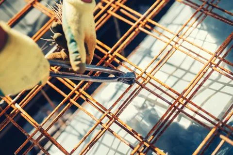 Construction site details with worker using wire rod and pliers for securing  Stock Photos