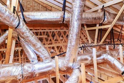 Construction site ductwork installation in attic area of new building project Stock Photos