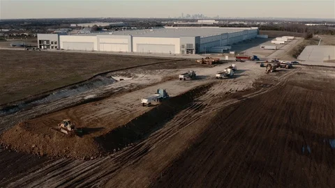 On a construction site, dump trucks and a catepillar tractor build up the Stock Footage 123563091