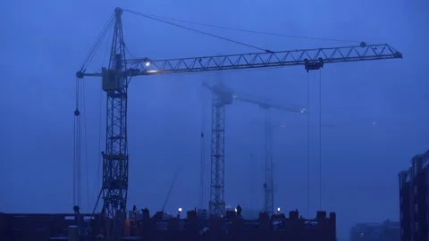 Construction site at dusk with purple sky. Silhouette of high tower cranes works Stock Footage 160389330