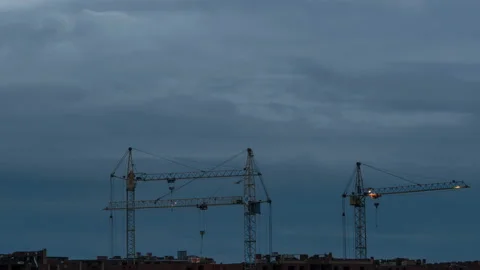 Construction site at dusk with purple sky. Silhouette of high tower cranes works Stock Footage 160389813