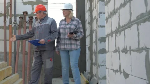 Construction site engineer showing building progress with architect Stock Footage 315600159