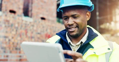 Construction site, engineering and typing with black man, tablet for online.. Stock Photos