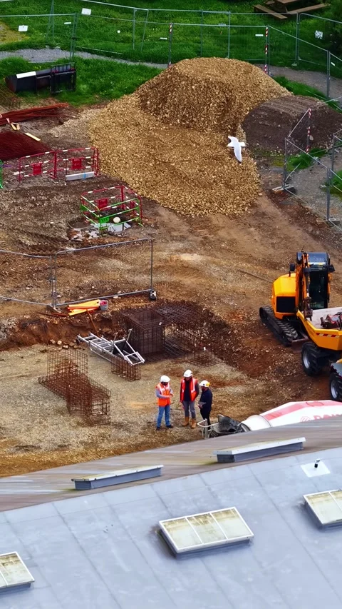 Construction site with engineers supervising foundation work near heavy Stock Footage 336240343