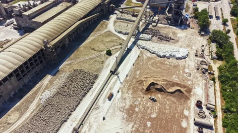 Construction site with equipment and materials near a factory during daylight Stock Footage 340955458