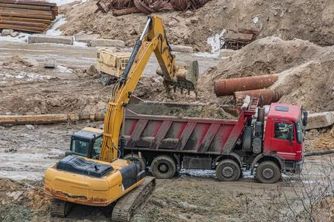 Construction Site with Excavator and Dump Truck Working Together Stock Photos