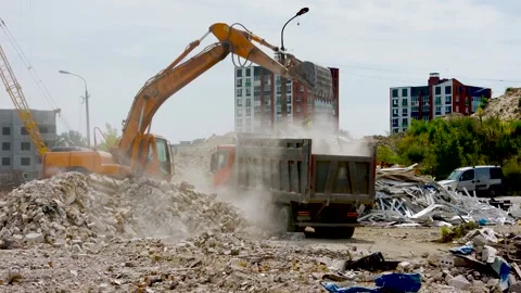 Construction site. Excavator with bucket loads remains of demolished, destroyed Stock Footage 313302415