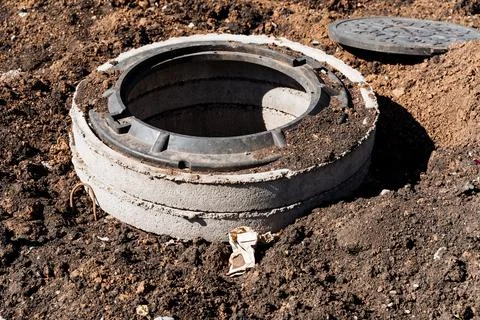 Construction site with exposed manhole, digging earth for concrete structur.. Stock Photos