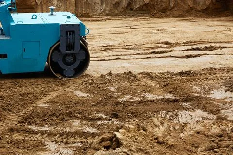 Construction site features a blue roller compacting earth on a freshly exca.. Stock Photos