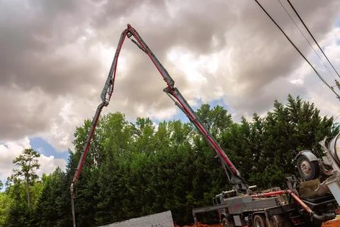Construction site features concrete pump reaching towards Stock Photos