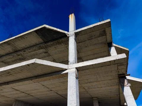 Construction site features concrete structure under clear blue sky at midday Stock Photos