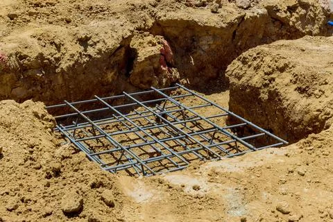 Construction site features prepared foundation with reinforcement bars laid out 스톡 사진