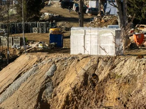 A construction site features stacked building materials and machinery near a Stock Photos