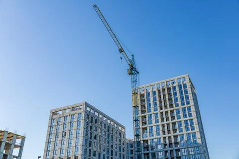 A construction site features two residential buildings nearing completion, .. 库存照片