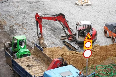 Construction site features various machines working on ground preparation for a Stock Photos