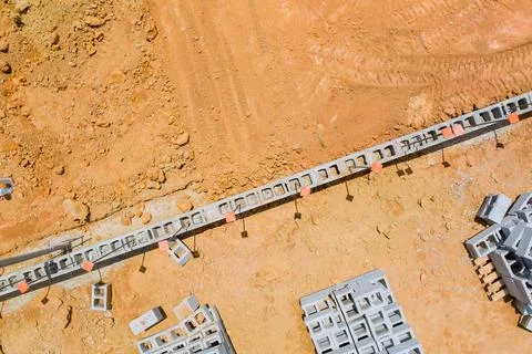 Construction site featuring concrete blocks arranged on sandy landscape during Stockfoto's