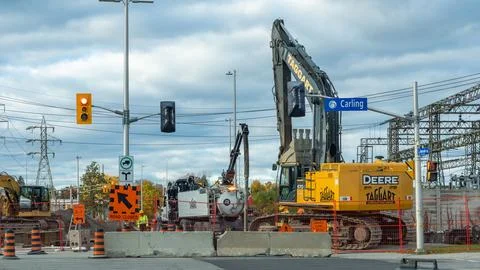 Construction site featuring heavy machinery including a yellow John Deere Stock Photos