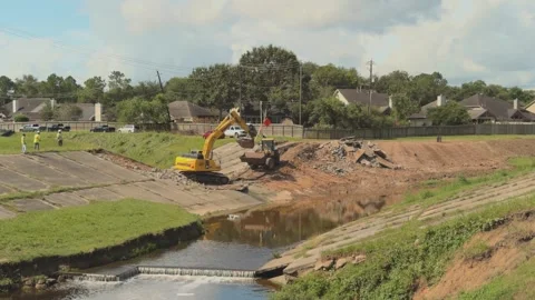A construction site with heavy equipment operators using an excavator and a Stock Footage 336553543