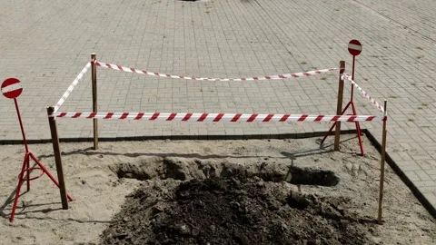 Construction site hole marked off with tape, awaiting further work or inspection Stock Footage 281139984