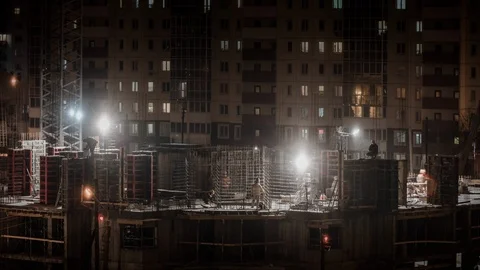 Construction site housing estate constructors working at winter night snowing Stock Footage 103467328