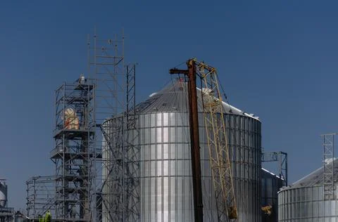 Construction site. Installation of cylindrical silos for grain storage. Metal Stock Photos