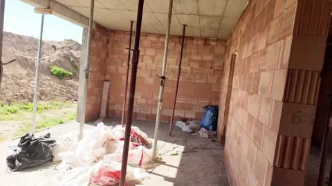 Construction site interior with brick walls and support poles, progress view. Stock Footage 333830192
