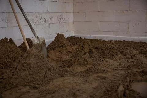 Construction Site Interior with Sand and Unfinished Walls 库存照片