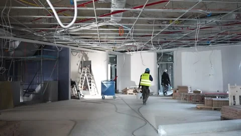Construction site interior with workers walking through unfinished building Stock Footage 332834843